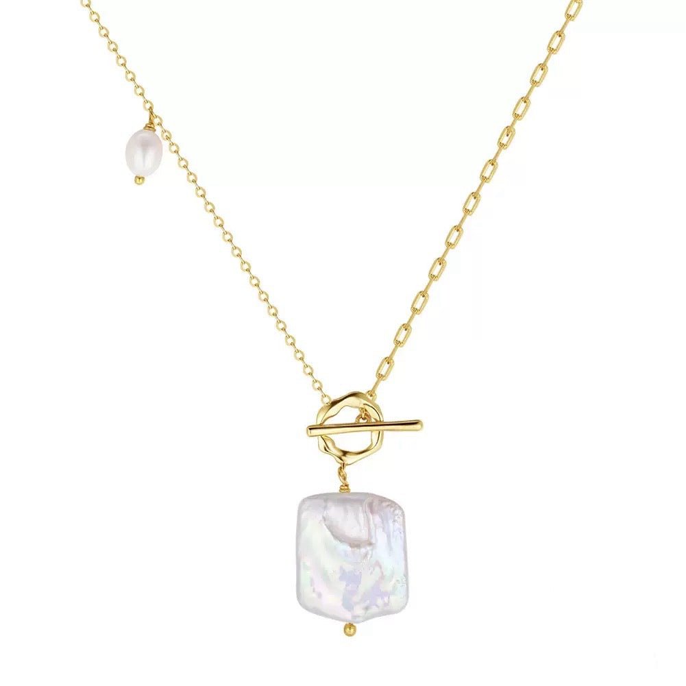a close up of a necklace with pearls
